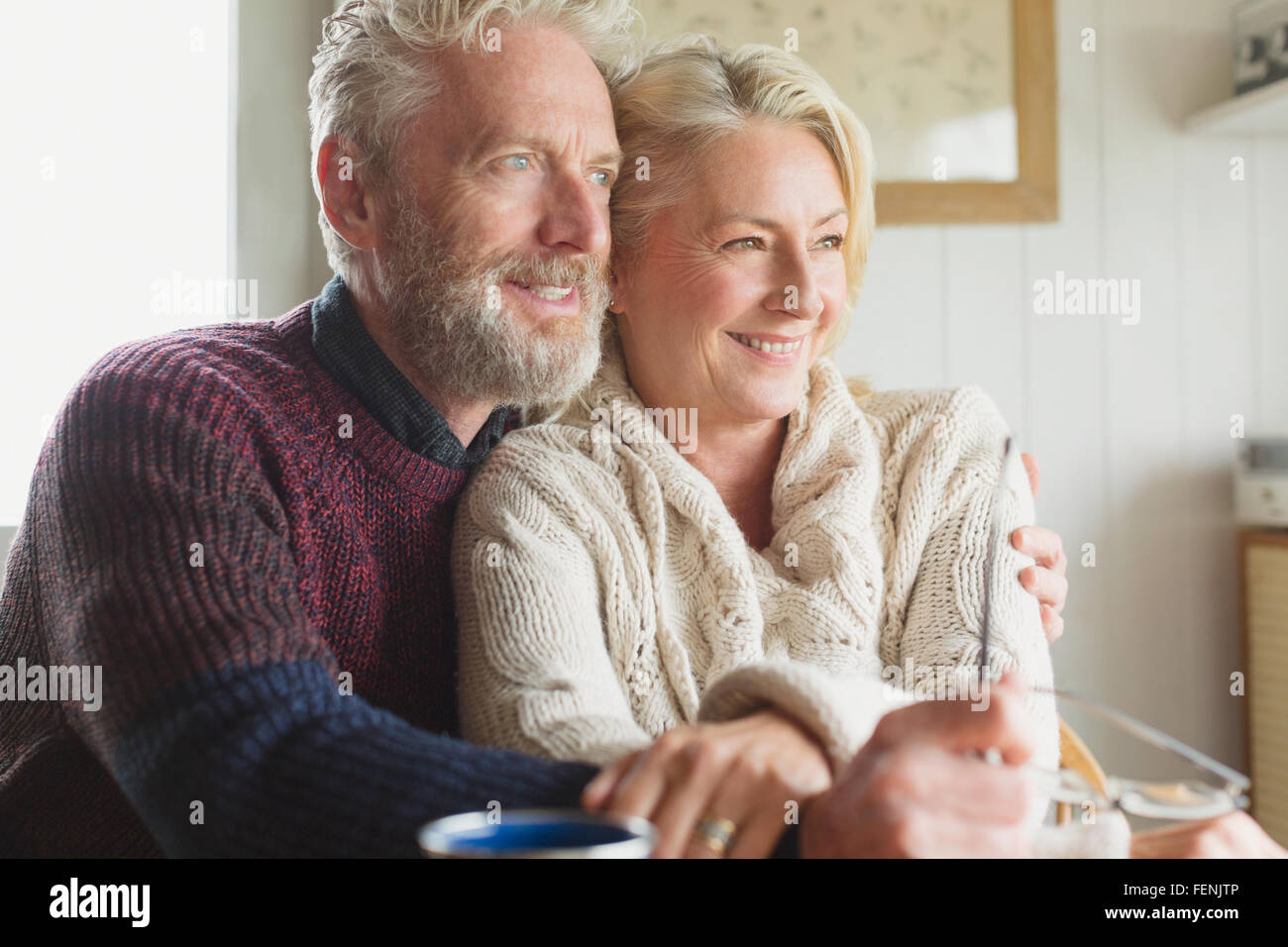 Smiling senior couple hugging and looking away Banque D'Images