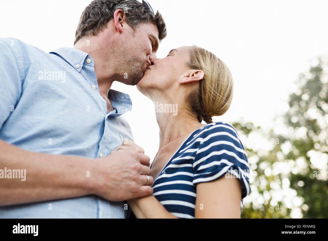 Romantic couple kissing in park Banque D'Images