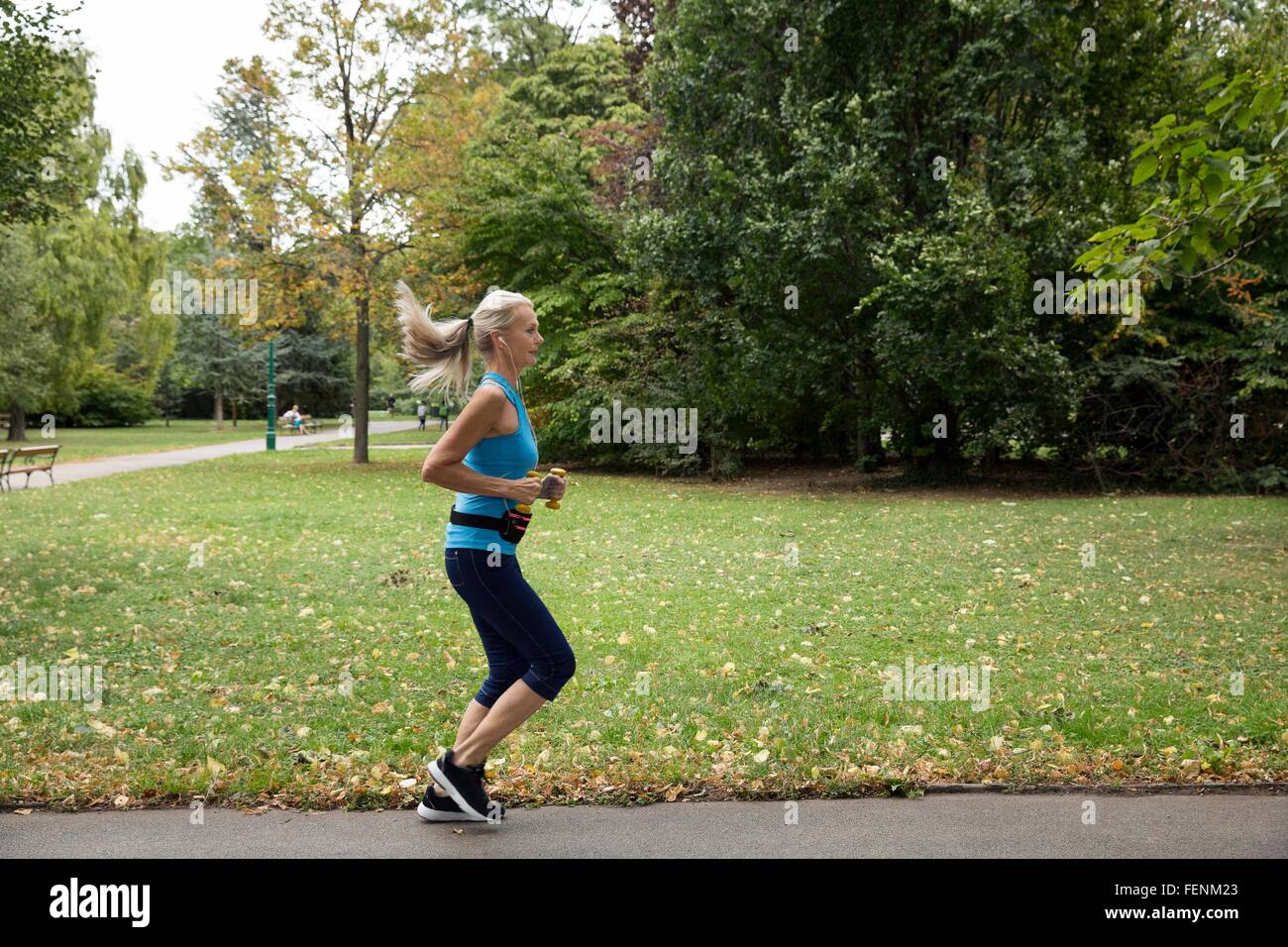 Femelle adulte runner running in park Banque D'Images