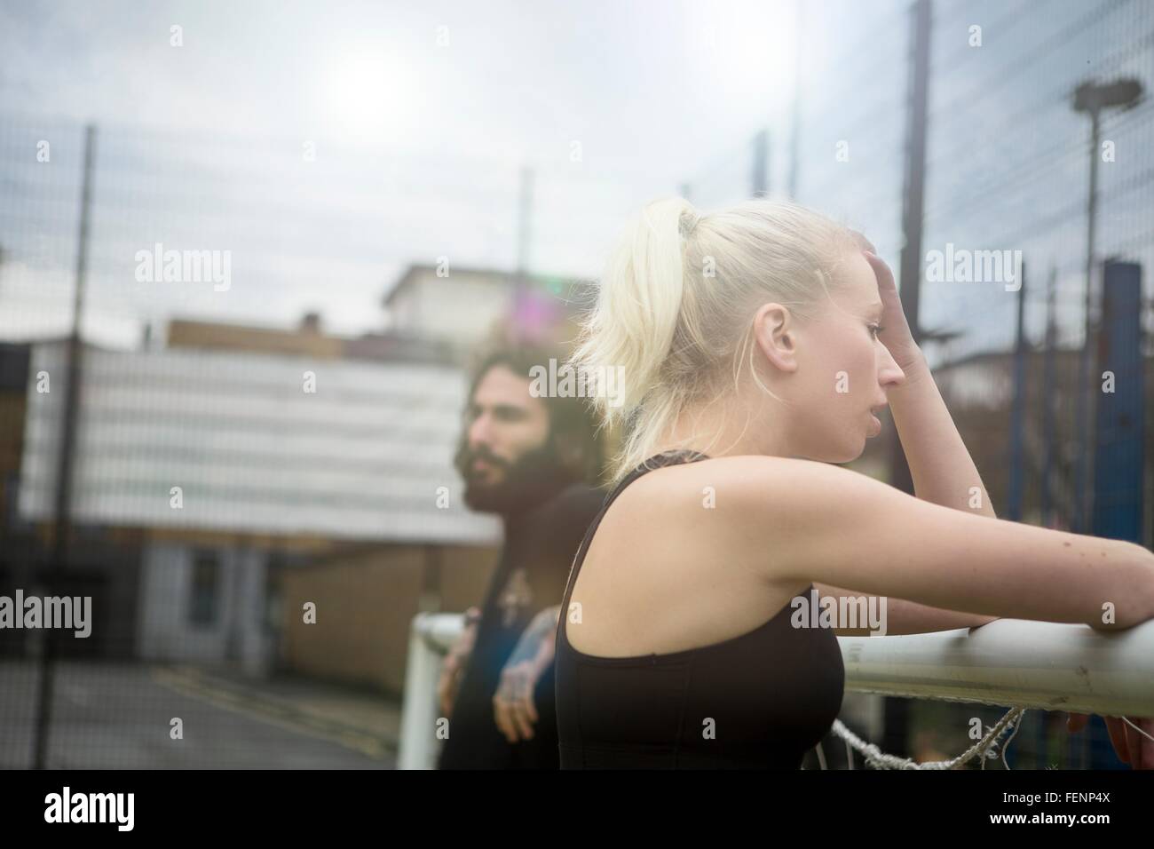 Jeune Femme prenant une pause, se penchant sur l'objectif de football Banque D'Images