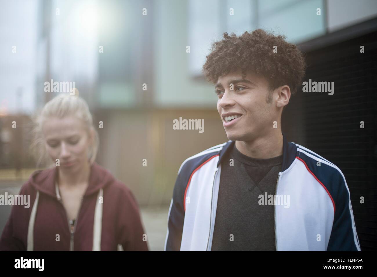 Young man and woman walking in street Banque D'Images