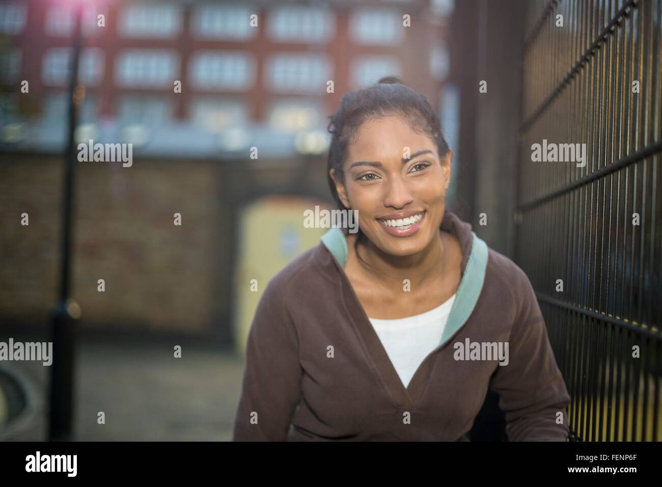 Jeune femme à côté de clôture, smiling Banque D'Images