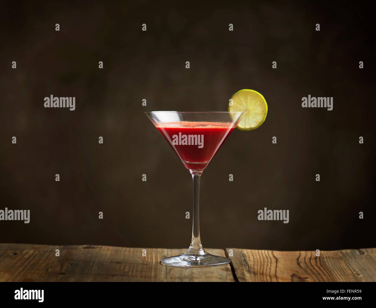Jus cru dans verre à cocktail garni d'une tranche de lime Banque D'Images