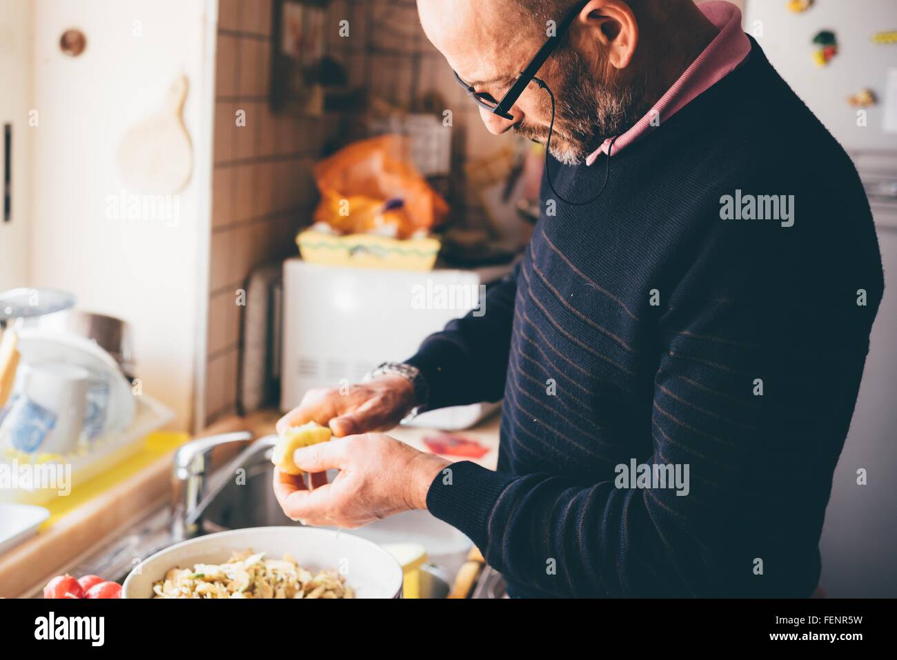 Man slicing artichauts en cuisine Banque D'Images