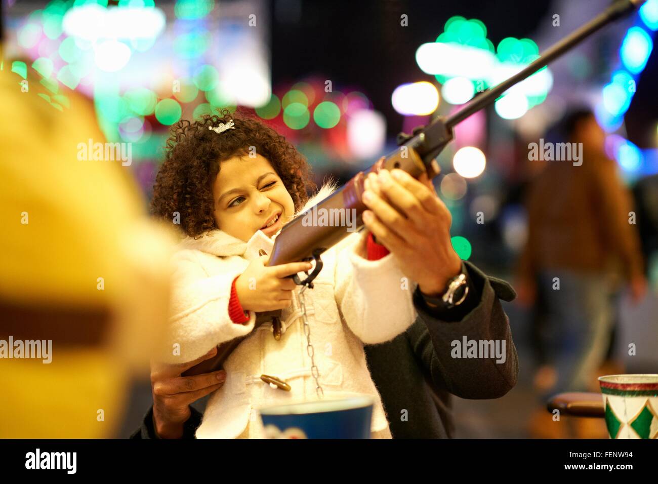 Père fille aidant au fusil à tir à la fête foraine Banque D'Images