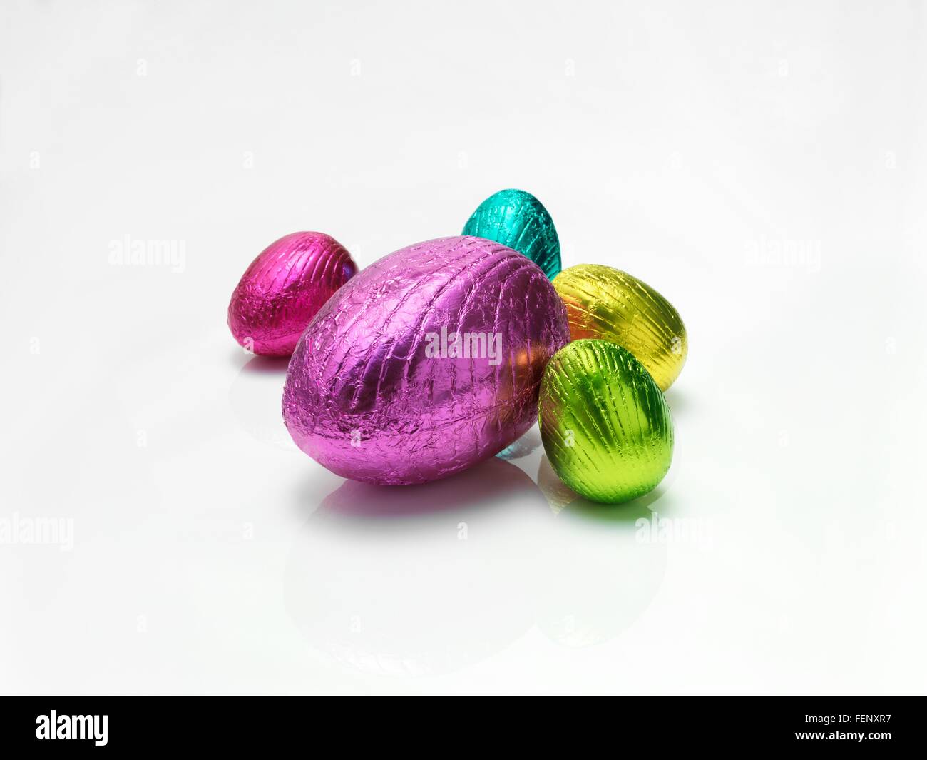 Les oeufs de Pâques colorés en aluminium brillant sur fond blanc Banque D'Images
