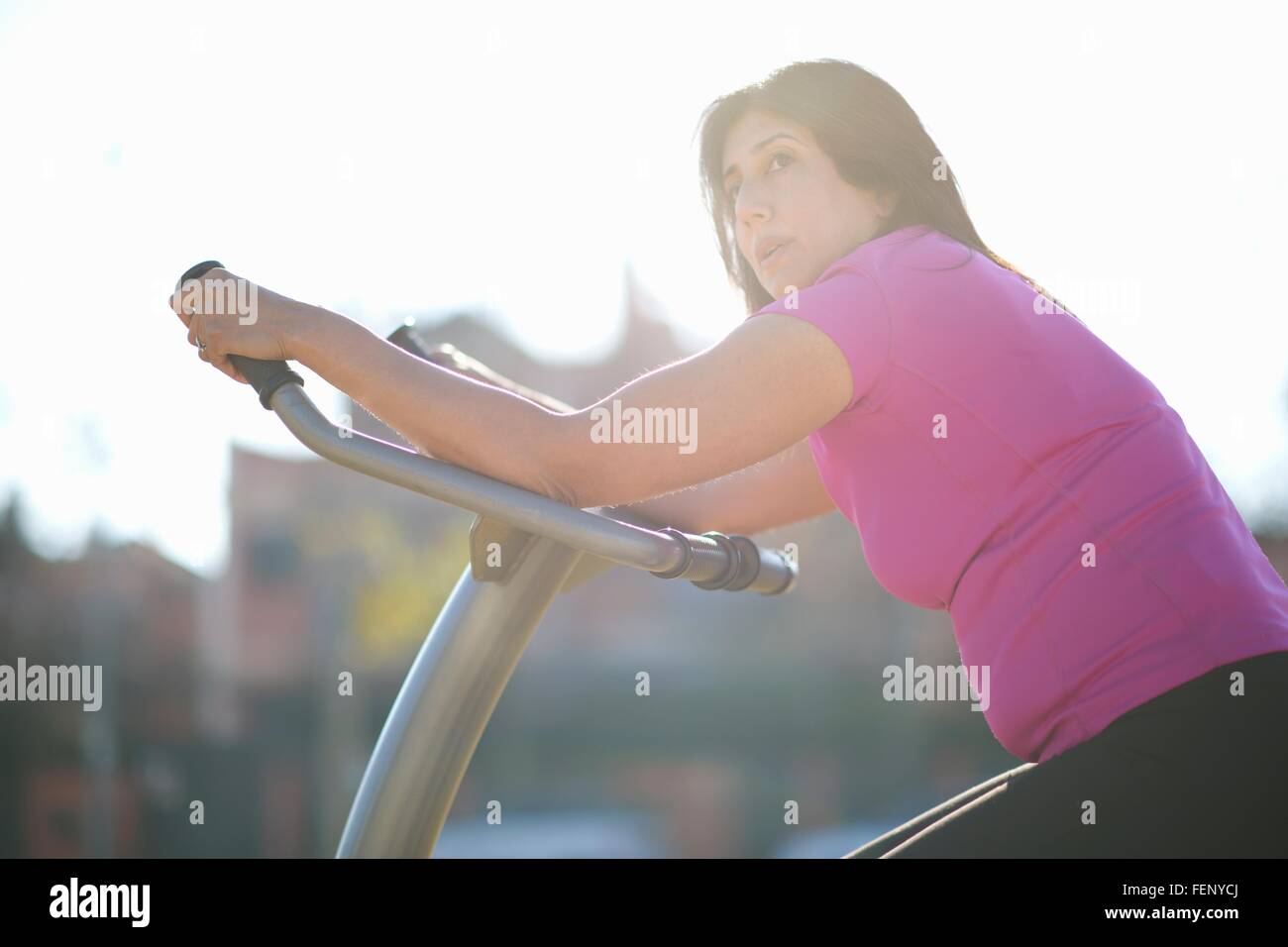 Vue latérale d'une femme mature sur l'équipement d'exercice en plein air à l'écart Banque D'Images