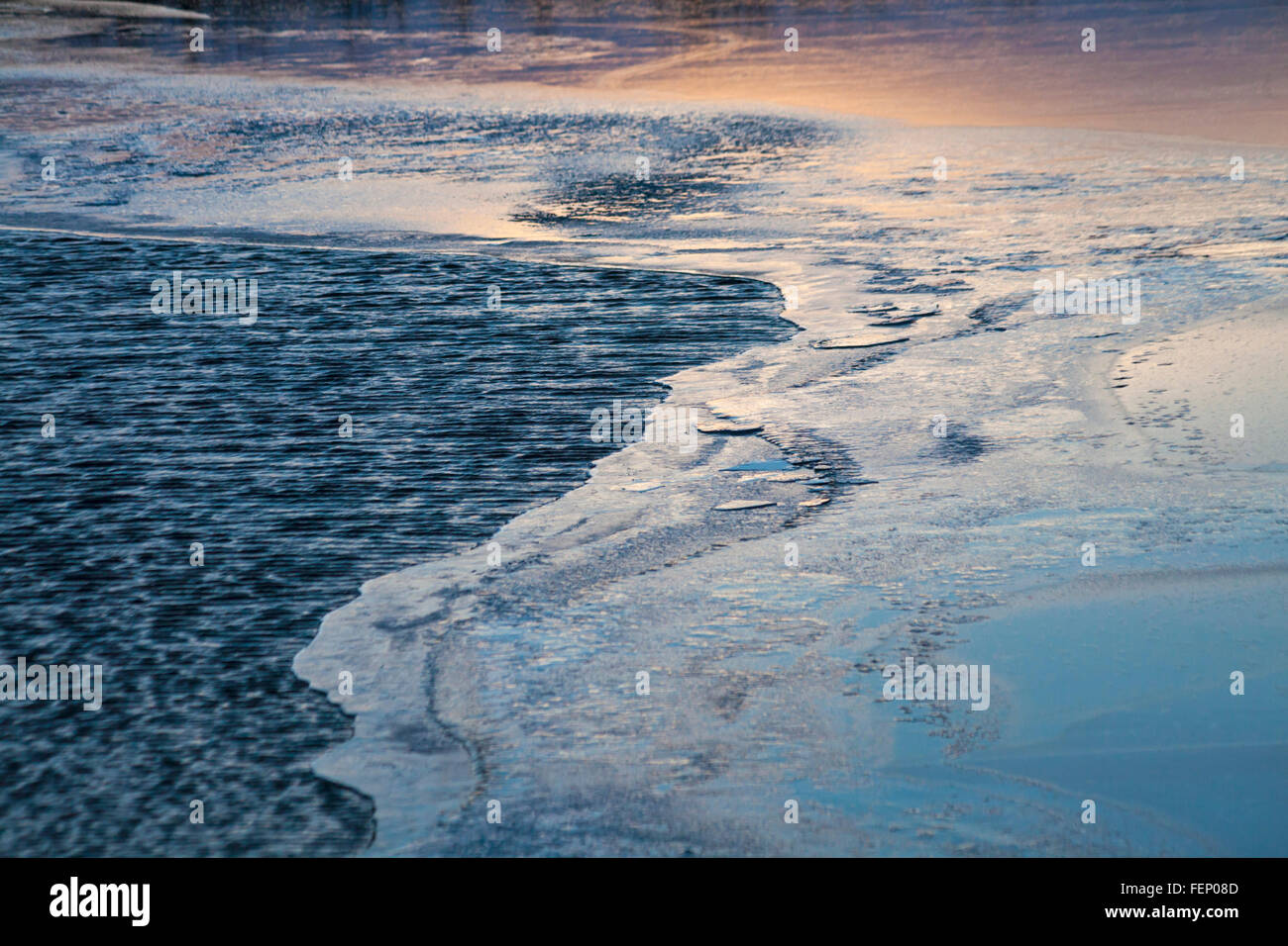 Les couleurs au coucher du soleil se reflétant dans l'eau gelée dans l'Islande en Janvier Banque D'Images