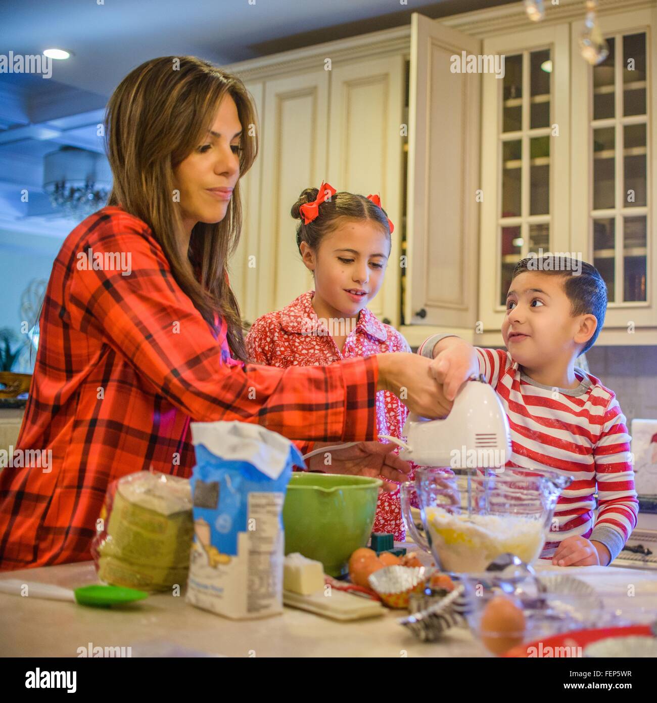 La mère et les enfants dans la cuisine, à l'aide d'un fouet à main Banque D'Images