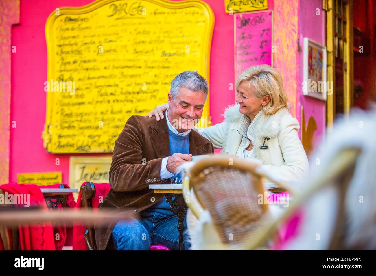 Mature couple drinking coffee at sidewalk cafe colorés, Majorque, Espagne Banque D'Images