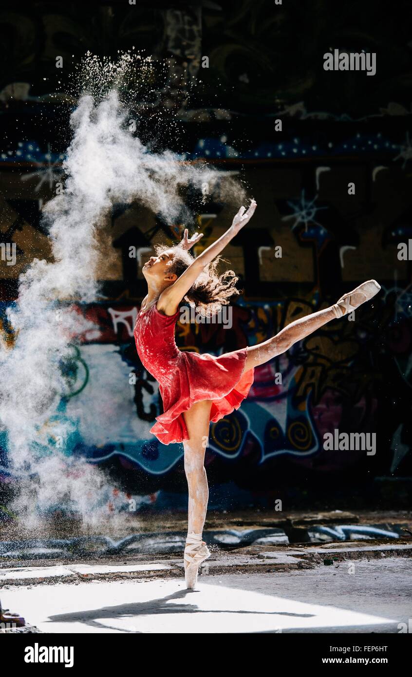 Danseuse de ballet de poudre blanche de diffusion en face de graffitis Banque D'Images