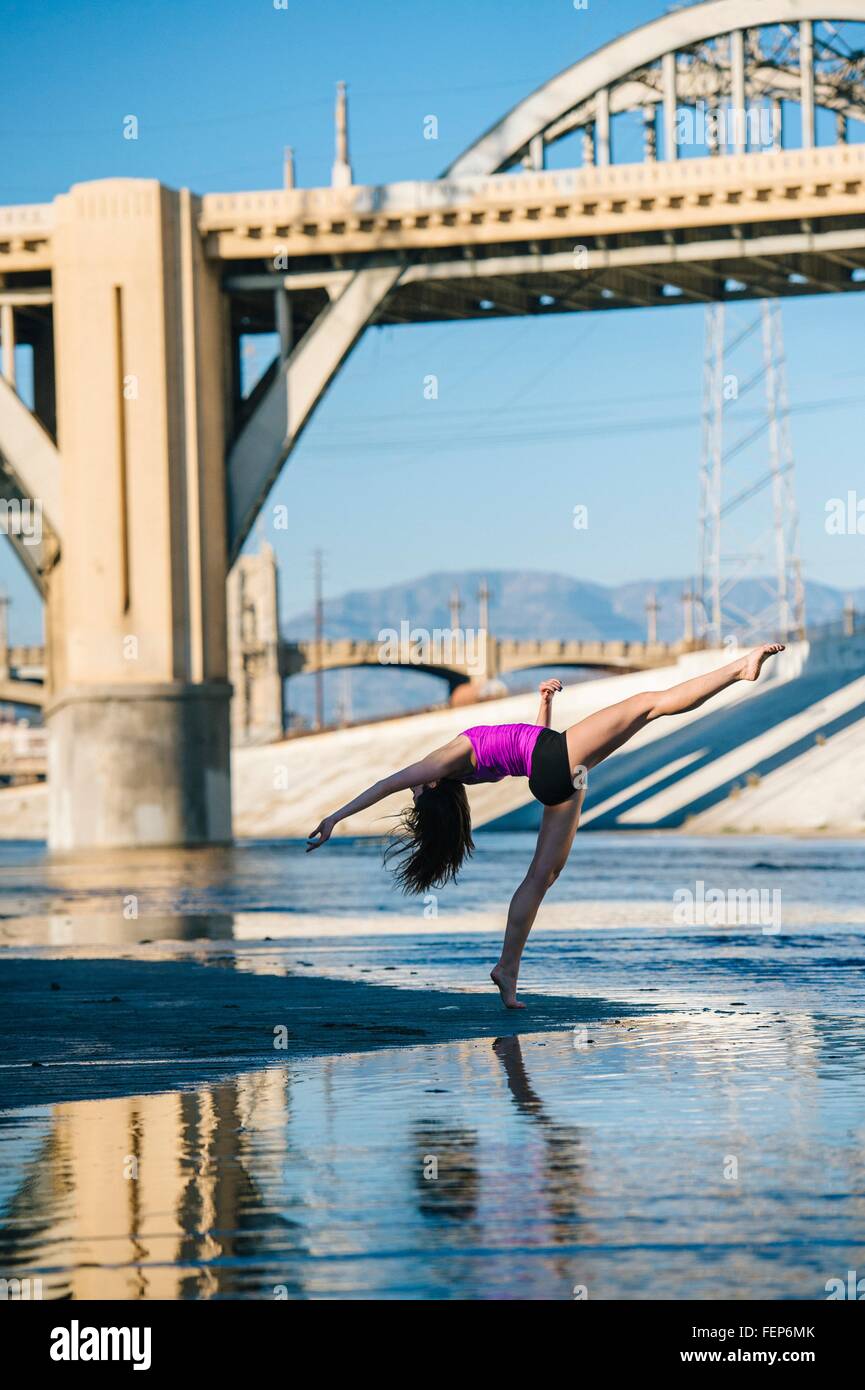Vue latérale du danseur, jambe soulevée, penché au-dessus de l'arrière à l'avant du pont, Los Angeles, Californie, USA Banque D'Images
