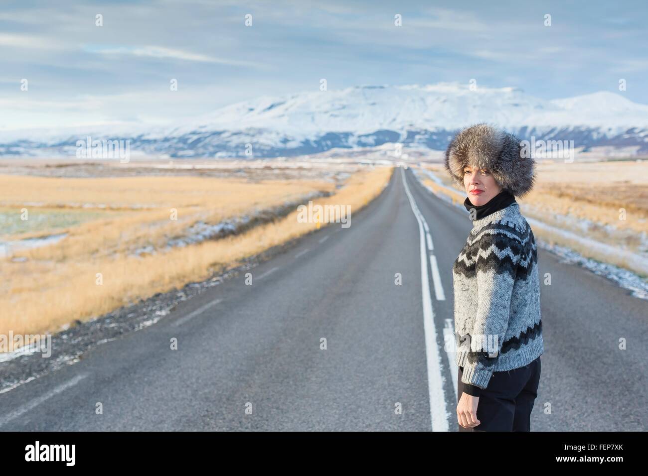 Young woman standing in middle of country road, Islande Banque D'Images