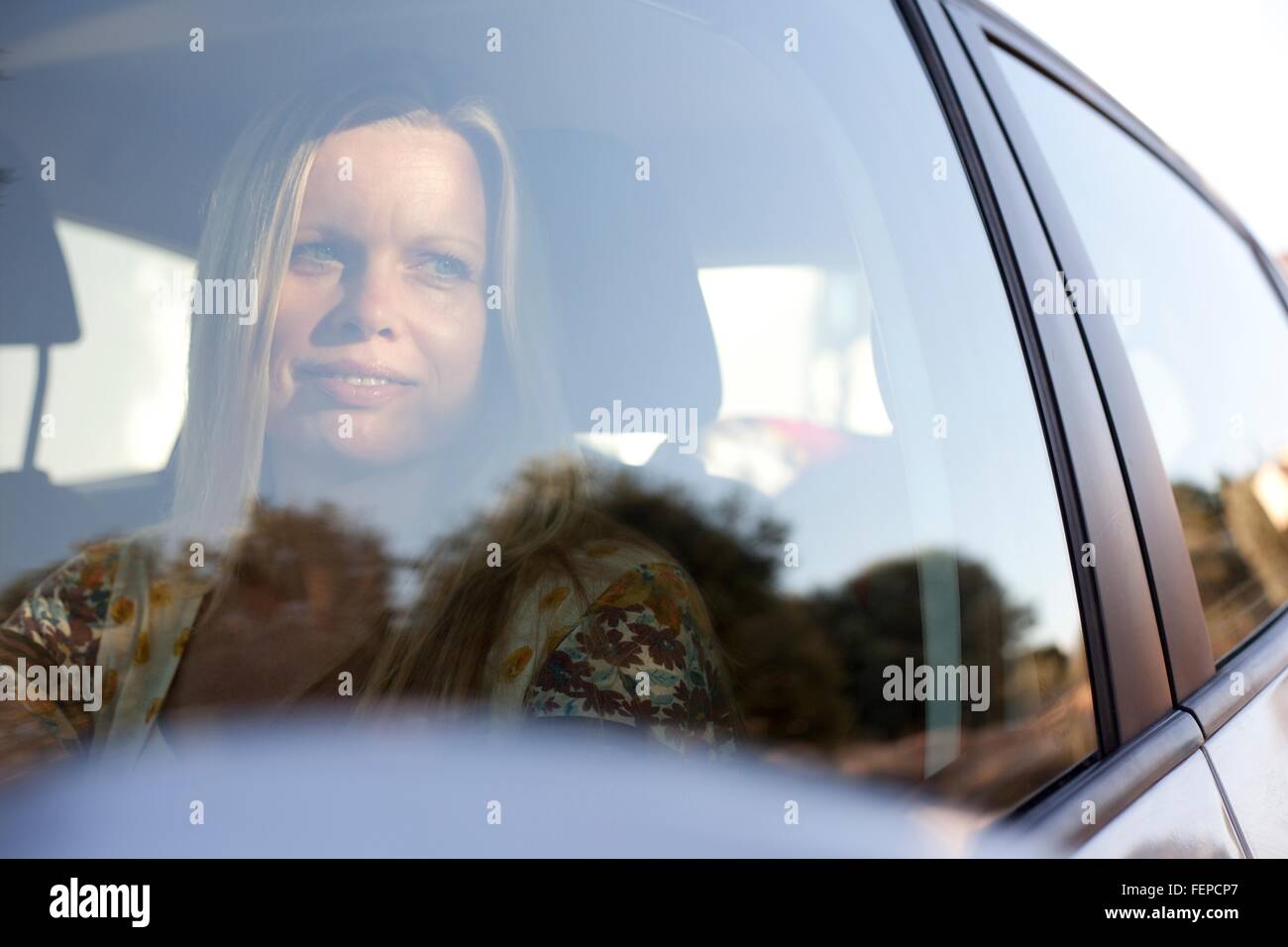 Femme mature à l'intérieur de voiture à la recherche d'une fenêtre Banque D'Images