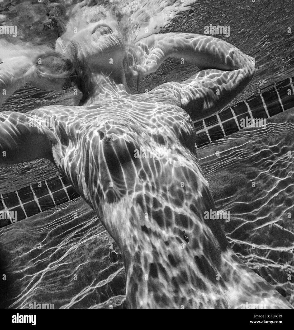 Woman swimming naked underwater Banque D'Images