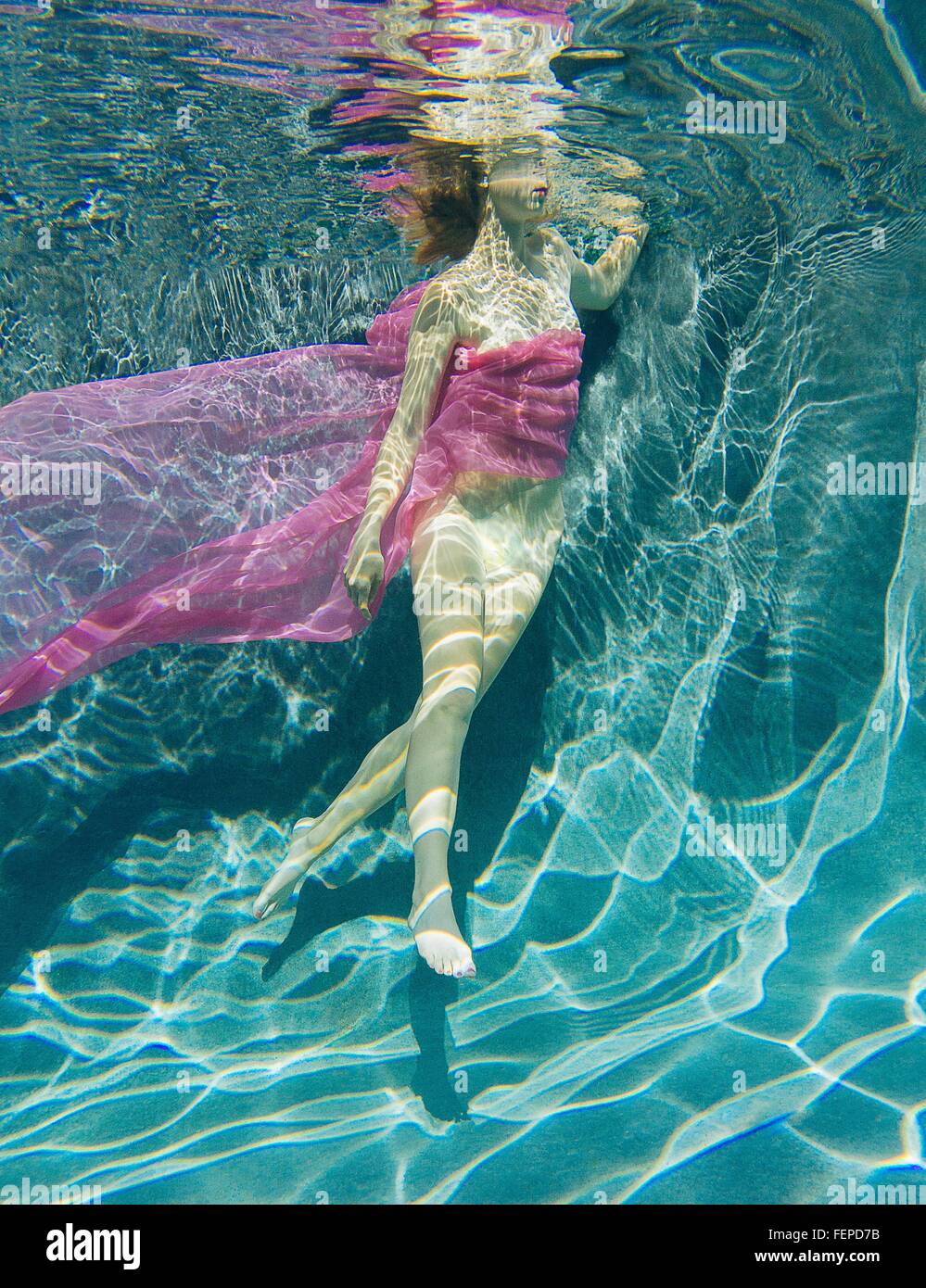 Femme drapée dans une structure sous-marine à moitié nu Banque D'Images