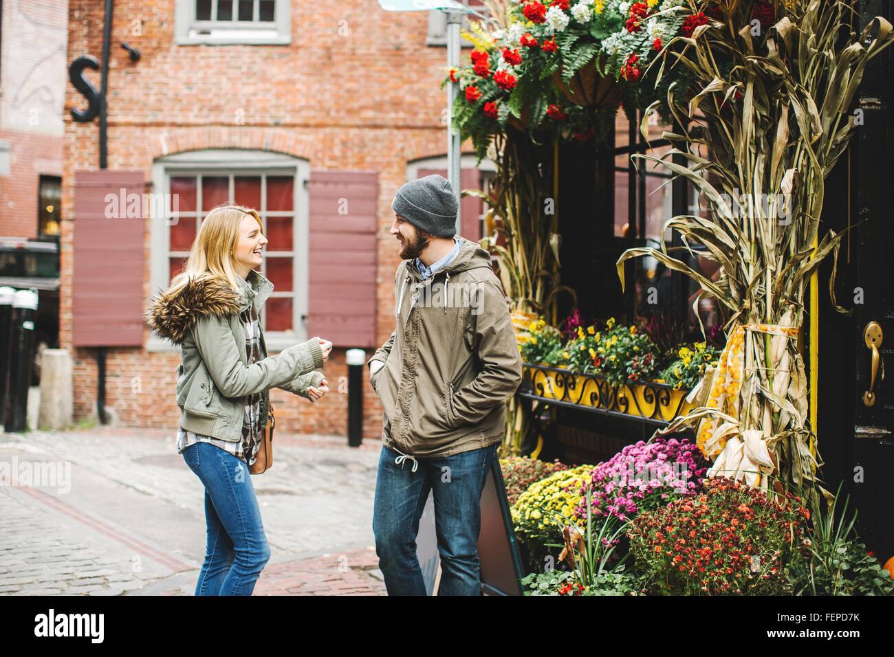 Jeune couple chatting on rue pavée à l'extérieur les fleuristes, Boston, Massachusetts, USA Banque D'Images