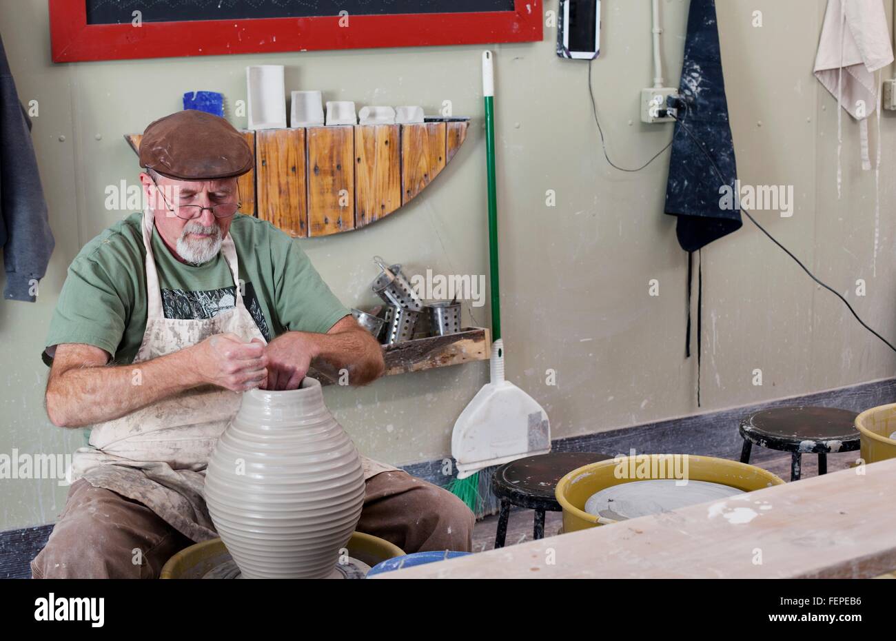Potter assis à la télévision porte roue poterie vase d'argile en forme Banque D'Images