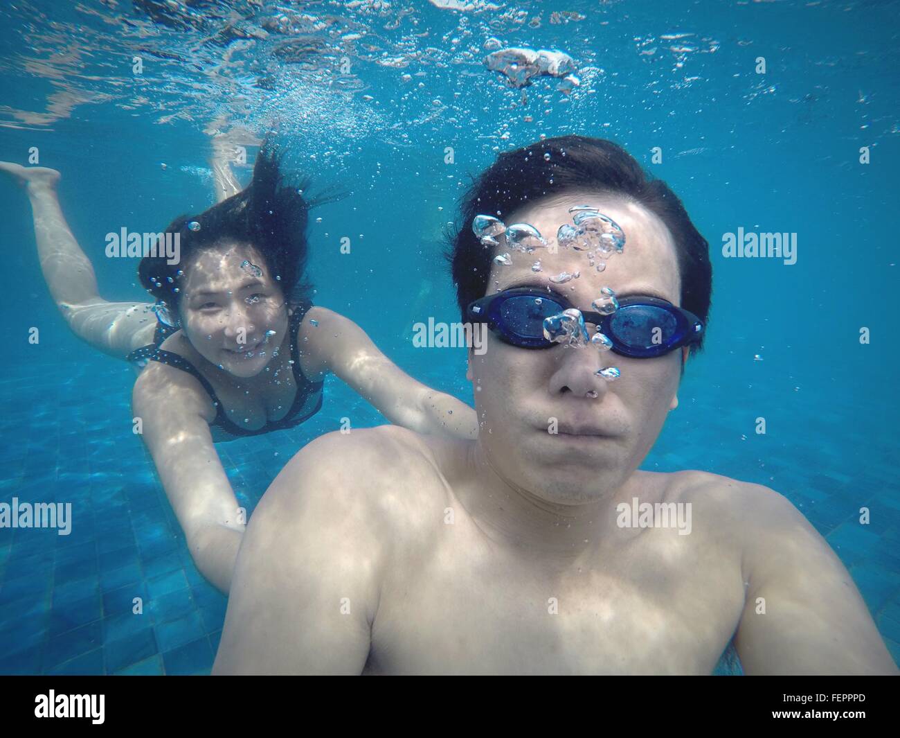 Homme avec Smiling Woman Swimming In Pool Banque D'Images