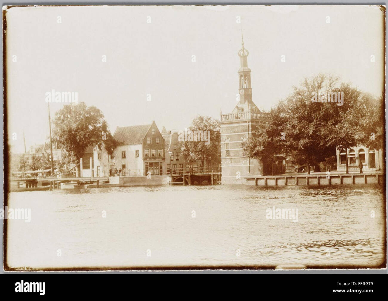 Une photographie de l'Accijnstoren, une tour d'impôt historique située à Alkmaar, prise vers 1900. Cette image montre les caractéristiques architecturales de la tour et son rôle dans l’histoire de la ville. Banque D'Images
