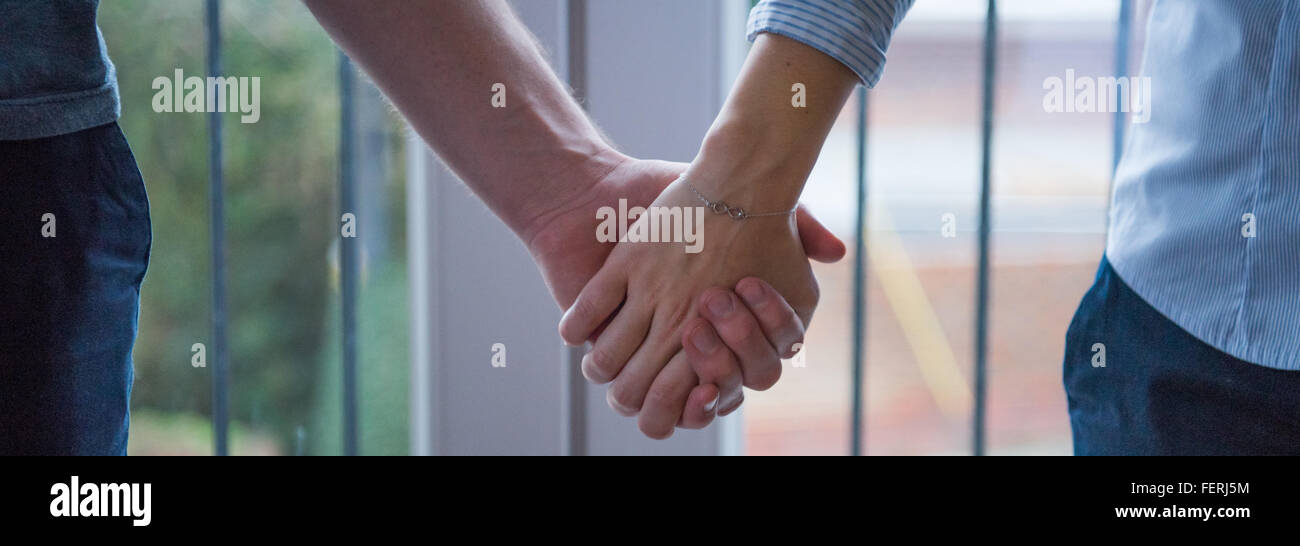 Deux personnes avec les mains ensemble en utilisant un bracelet avec symbole de l'infini Banque D'Images