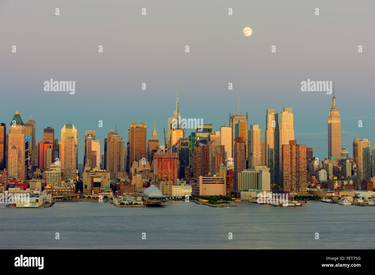 La Lune gibbeuse se trouve haut dans le ciel crépusculaire au cours de la New York City skyline le jour avant la pleine lune. Banque D'Images
