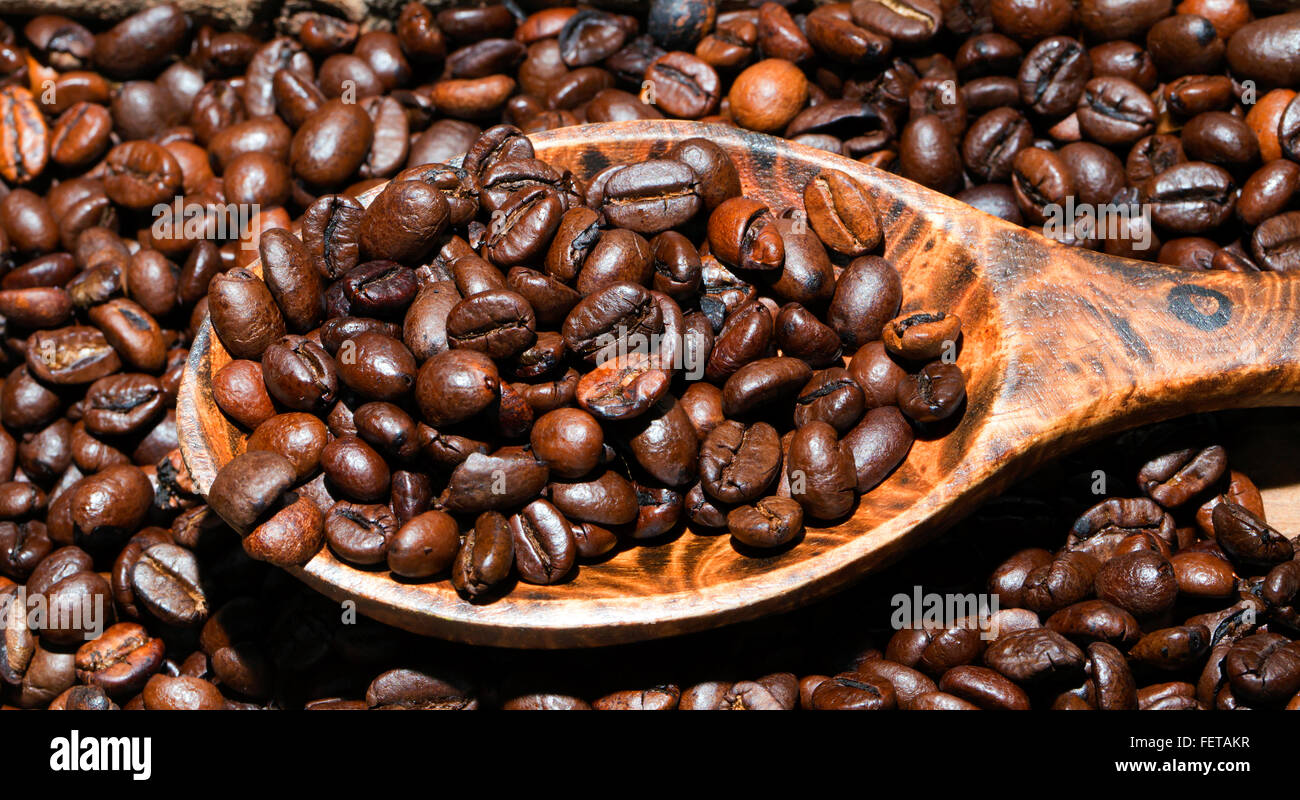 Les grains de café torréfiés sur cuillère en bois, l'Arabica et Robusta Banque D'Images