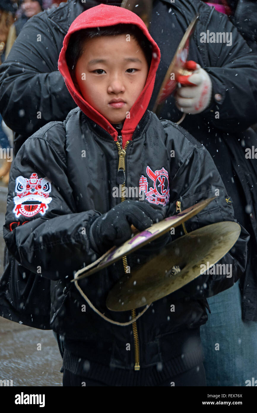 Un jeune garçon chinois jouant des cymbales dans le défilé du Nouvel An chinois sur Mott Street dans le quartier chinois, la ville de New York. Banque D'Images