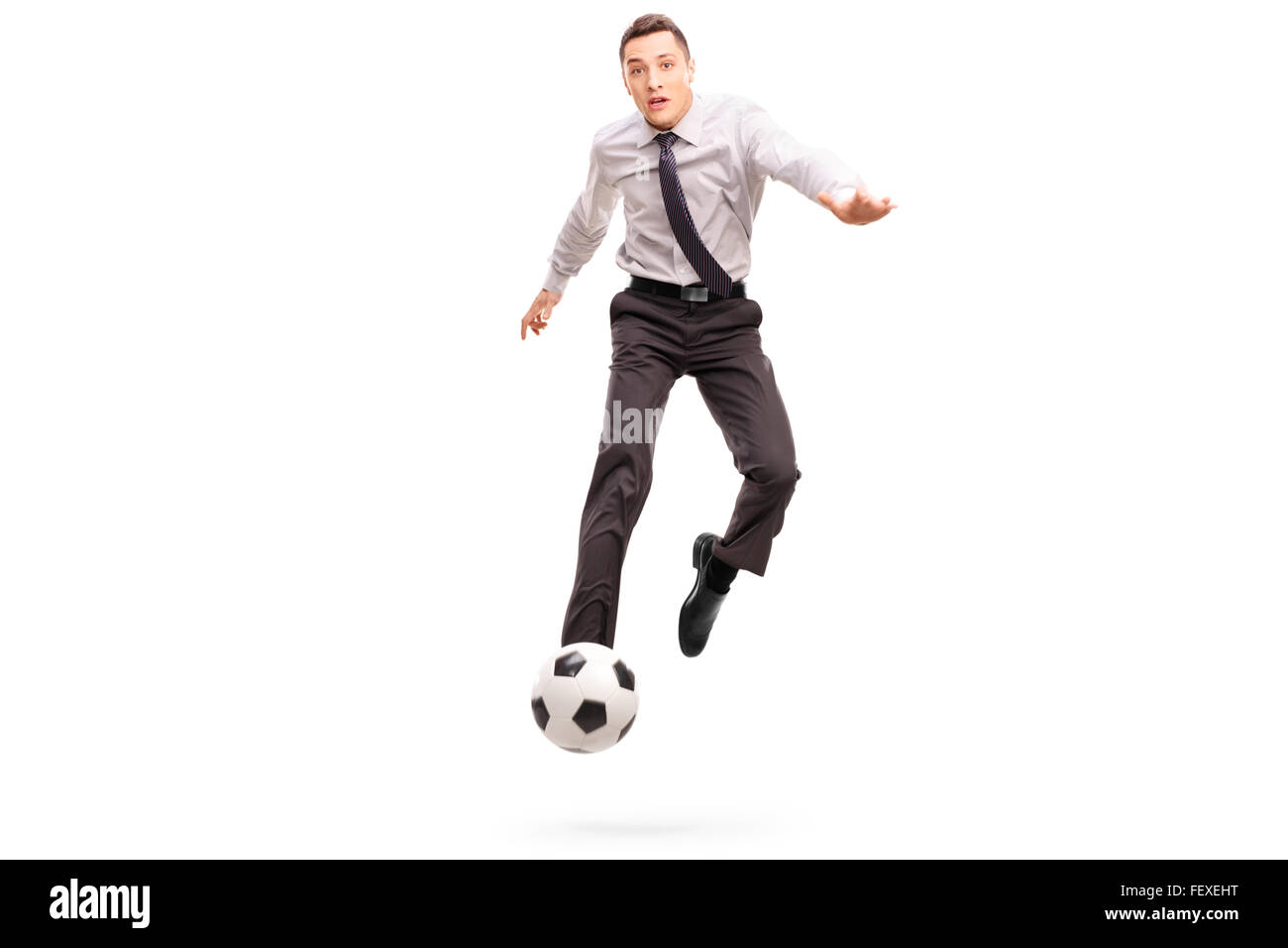 Portrait d'un jeune homme d'un coup de pied tourné en football l'air isolé sur fond blanc Banque D'Images