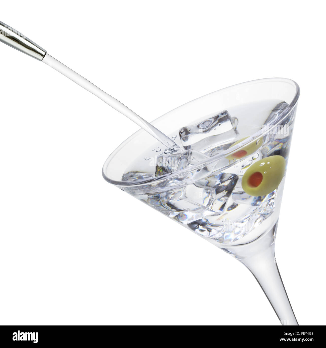 L'alcool et verser dans un verre à cocktail avec des glaçons et d'olive, isolé sur le fond blanc, chemin de détourage inclus. Banque D'Images