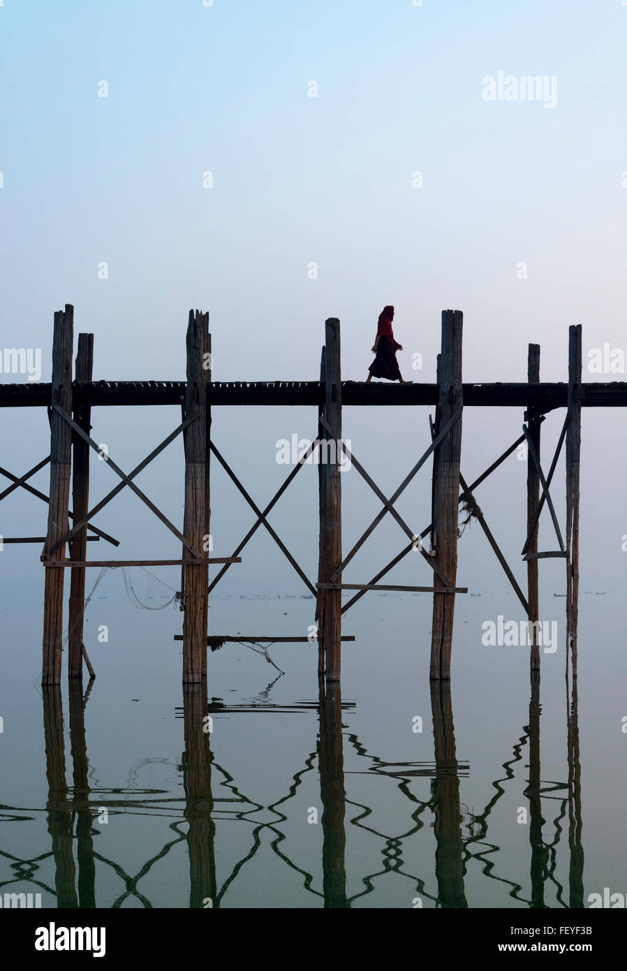 Le moine bouddhiste traverse le pont U Bein - le plus long pont en teck du monde dans Amarapura près de Mandalay, Myanmar (Birmanie Banque D'Images