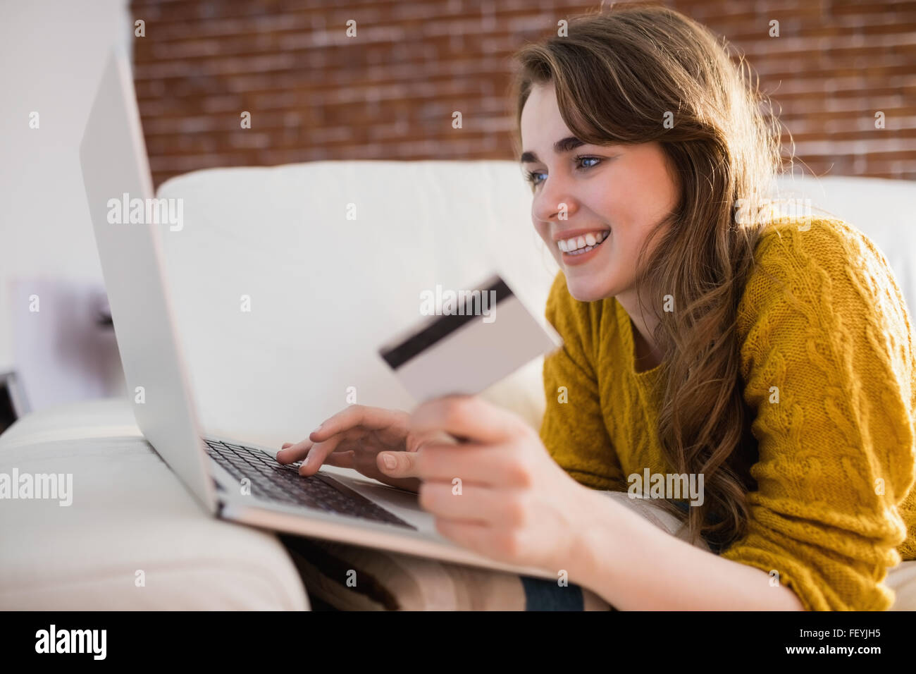 Jeune femme en utilisant sa carte de crédit pour acheter en ligne Banque D'Images