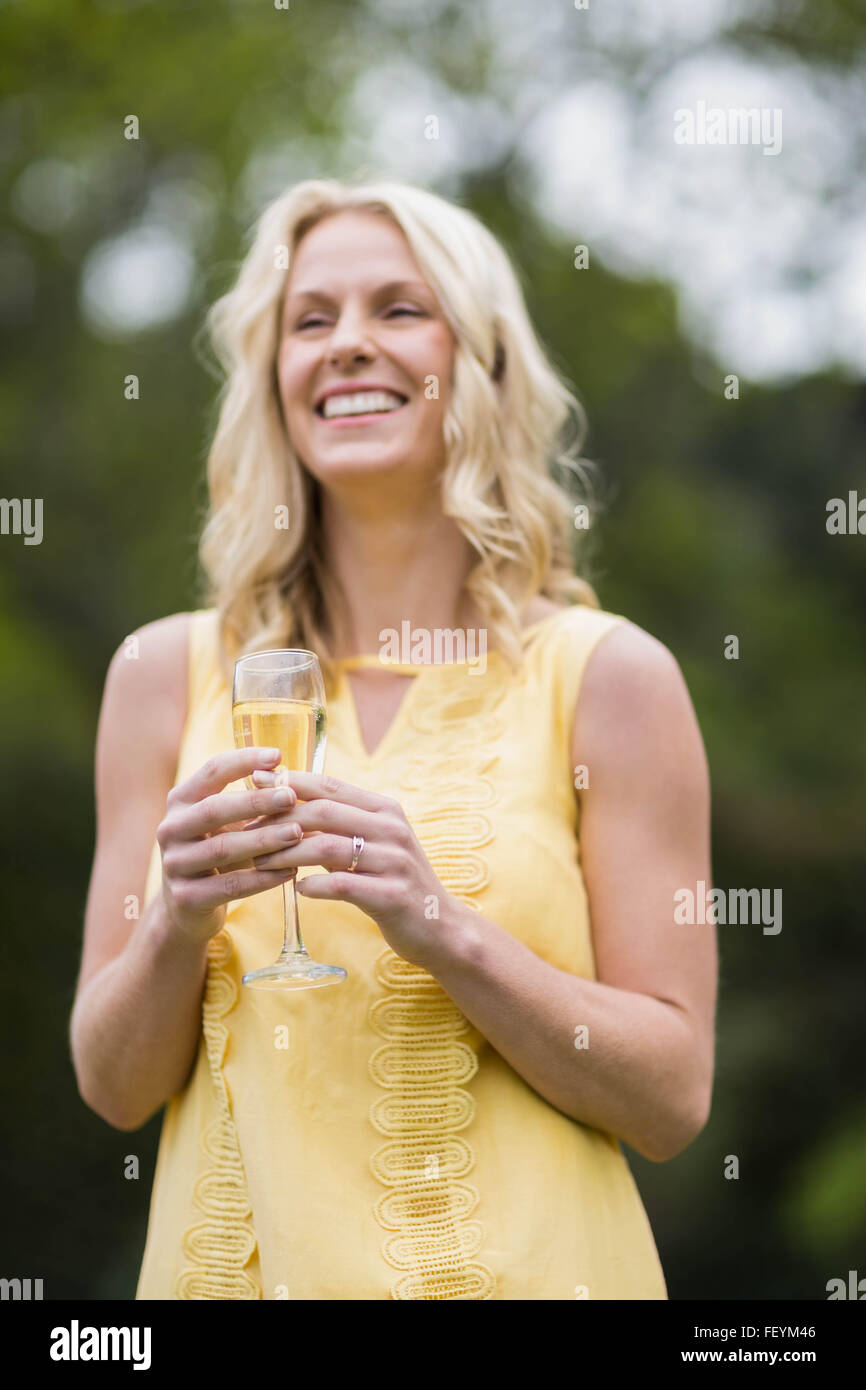 Happy woman drinking glass of champagne Banque D'Images