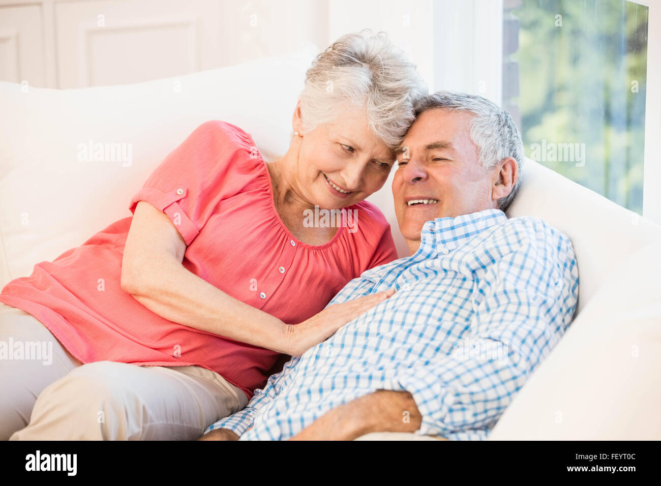 Happy senior couple lying on sofa Banque D'Images
