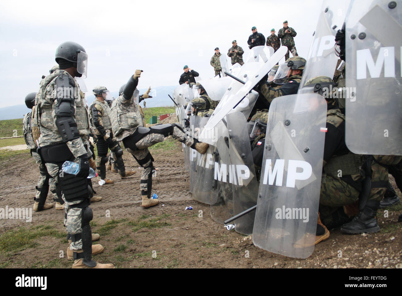 Un soldat de l'Armée américaine affecté à la Compagnie Alpha, 1er Bataillon interarmes, 252ème régiment d'armure, les tentatives visant à perturber une foule polonaise au cours d'une ligne de lutte antiémeute 10 Déc., 2015, l'exercice de formation au Camp Marechal de Lattre de Tassigny, au Kosovo. Le quartier général du bataillon 1-252 est le combat multinationales Group-East Commande Transférer poste au Kosovo, de la supervision de la Compagnie Alpha et soldats polonais, ainsi que les unités d'entreprise de l'Allemagne, la Hongrie et la Slovénie. Banque D'Images Un soldat de l'Armée américaine affecté à la Compagnie Alpha, 1er Bataillon interarmes, 252ème régiment d'armure, les tentatives visant à perturber une foule polonaise au cours d'une ligne de lutte antiémeute 10 Déc., 2015, l'exercice de formation au Camp Marechal de Lattre de Tassigny, au Kosovo. Le quartier général du bataillon 1-252 est le combat multinationales Group-East Commande Transférer poste au Kosovo, de la supervision de la Compagnie Alpha et soldats polonais, ainsi que les unités d'entreprise de l'Allemagne, la Hongrie et la Slovénie. Banque D'Images