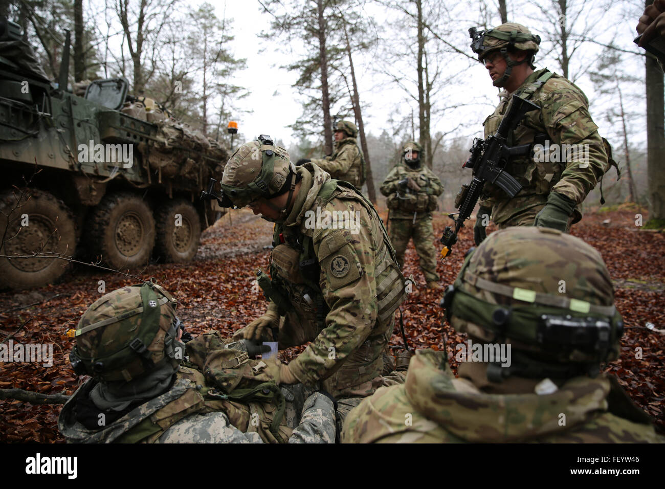 Un soldat américain, centre, affecté à la 2e Escadron, 2e régiment de cavalerie donne les premiers soins sur une victime simulée, à gauche, en effectuant l'opération défensive pendant l'exercice Allied Spirit IV à l'armée américaine dans le centre de préparation interarmées multinationale Hohenfels Domaine de formation, l'Allemagne, le 31 janvier 2016. L'esprit des alliés est un exercice d'entraînement de la force terrestre multinationale visant à accroître l'interopérabilité entre les États-Unis et les forces de l'OTAN. Banque D'Images