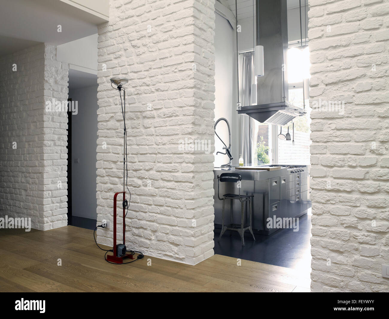 Appartement loft contemporain avec un mur de briques blanches et de la cuisine et d'une lampe Flos Toio faites par Banque D'Images