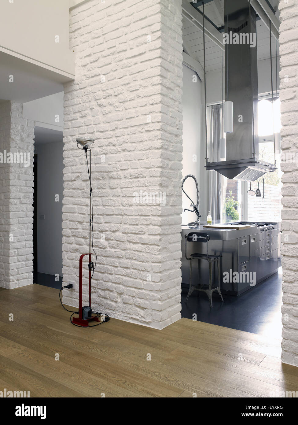 Appartement loft contemporain avec un mur de briques blanches et de la cuisine et d'une lampe Flos Toio faites par Banque D'Images