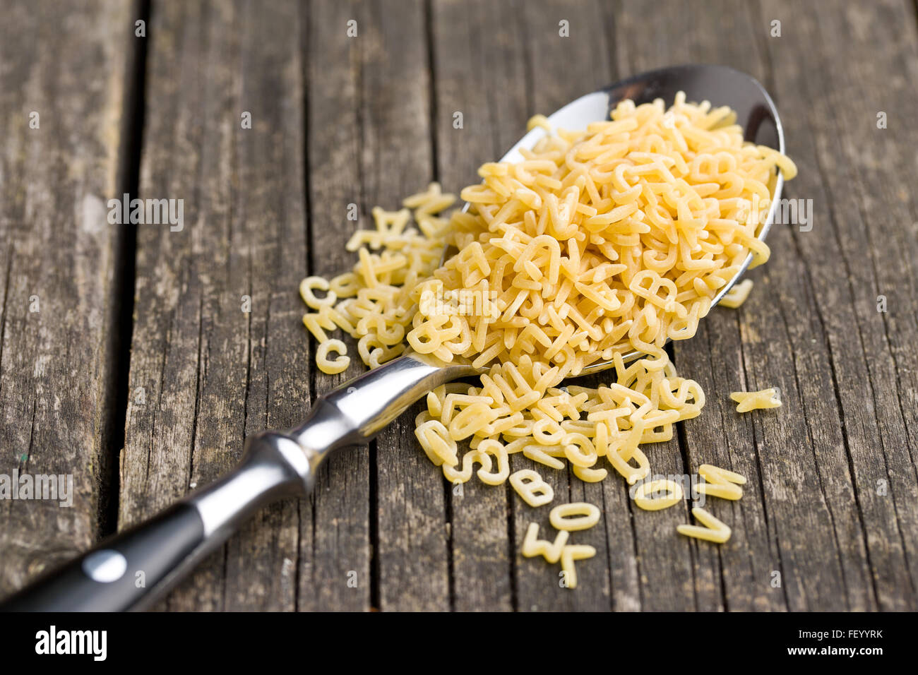 Les pâtes alphabet en cuillère sur table en bois ancien Photo Stock - Alamy