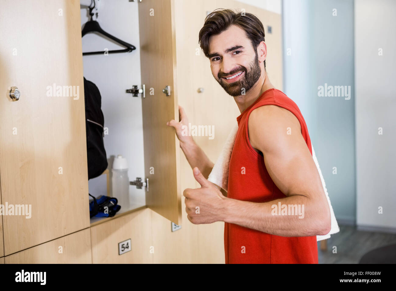Smiling man opening locker Banque D'Images