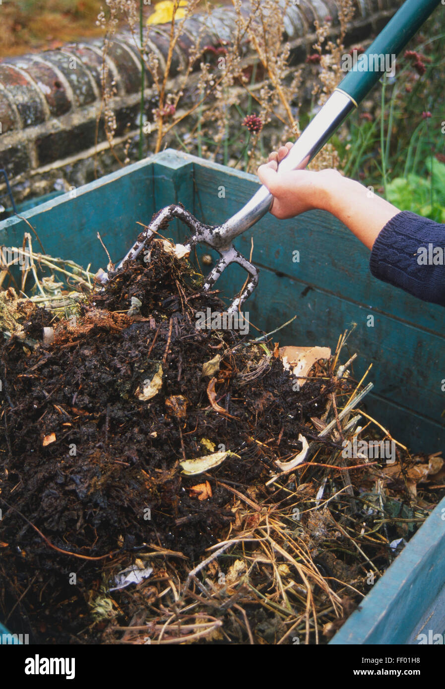 L'ajout de matériel jardin bac à compost avec une fourche à bêcher, augmentation de la vue. Banque D'Images