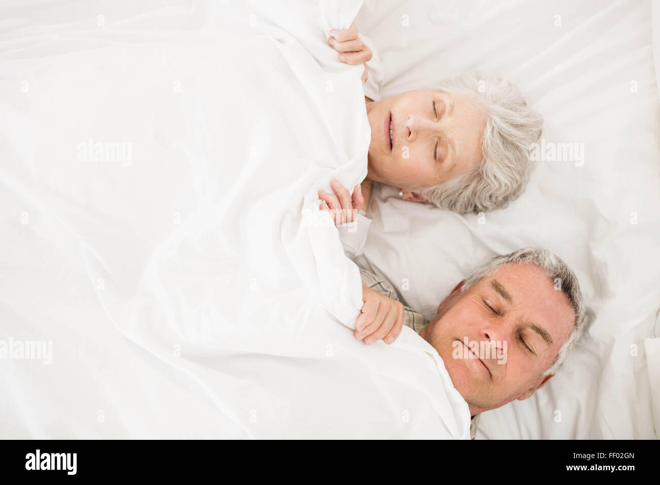 Senior couple sleeping in bed Banque D'Images