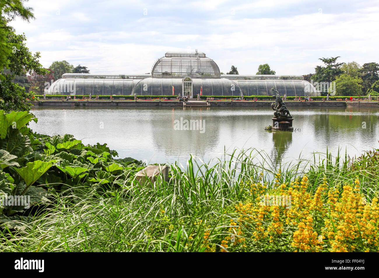 Vue sur le lac en direction de la Palm House à Kew Gardens en serre chaude serre Jardin Botanique Royal Botanic Gardens London England UK Banque D'Images