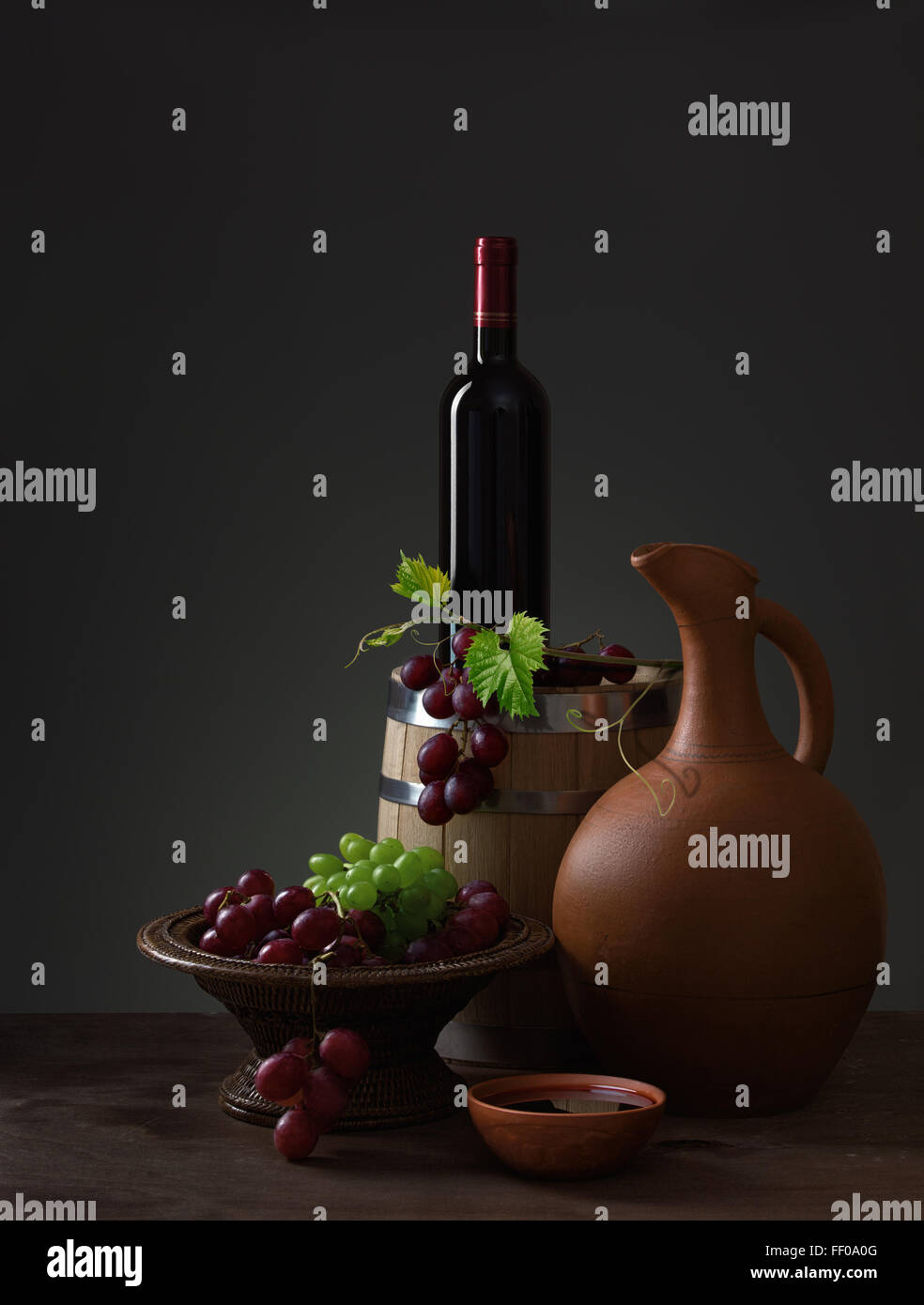 Bouteille de vin rouge, lanceur, raisins et tonneau en bois Banque D'Images