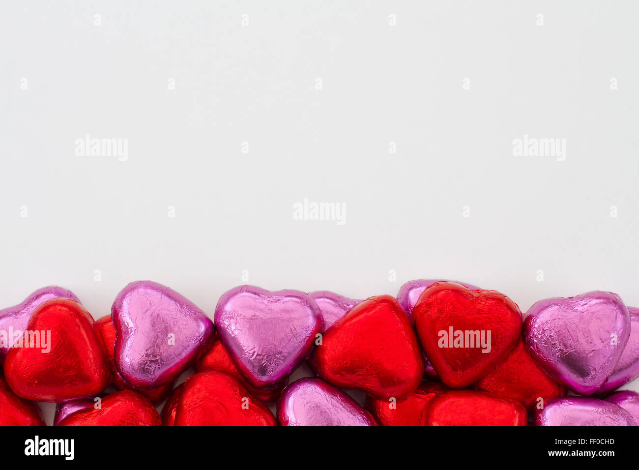 Chocolats en forme de coeur alignés sur le bord inférieur de l'image. Décoration valentine candy organisé dans la partie inférieure du cadre. Banque D'Images