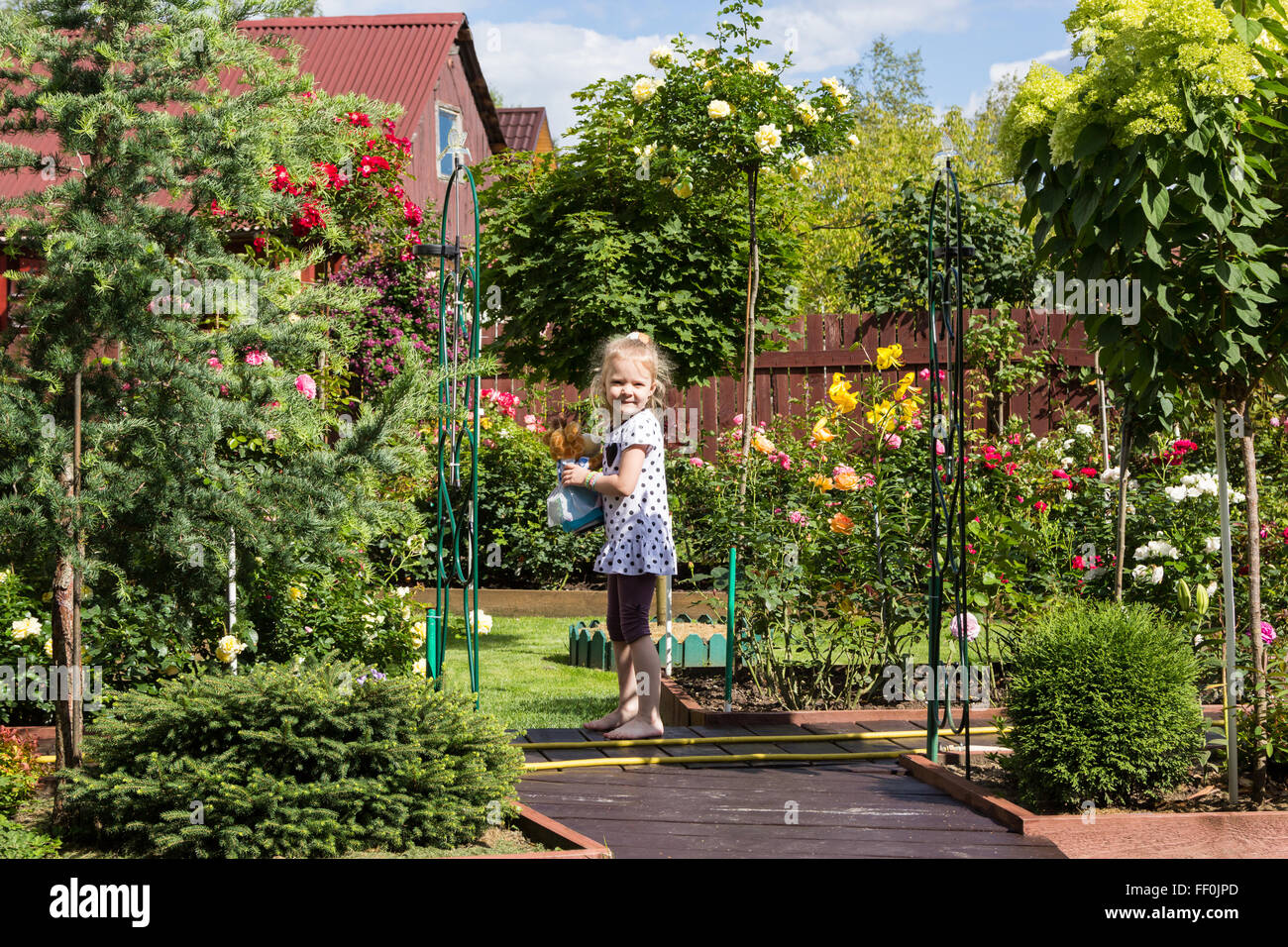 Fille qui marche sur le chemin dans un beau jardin Banque D'Images