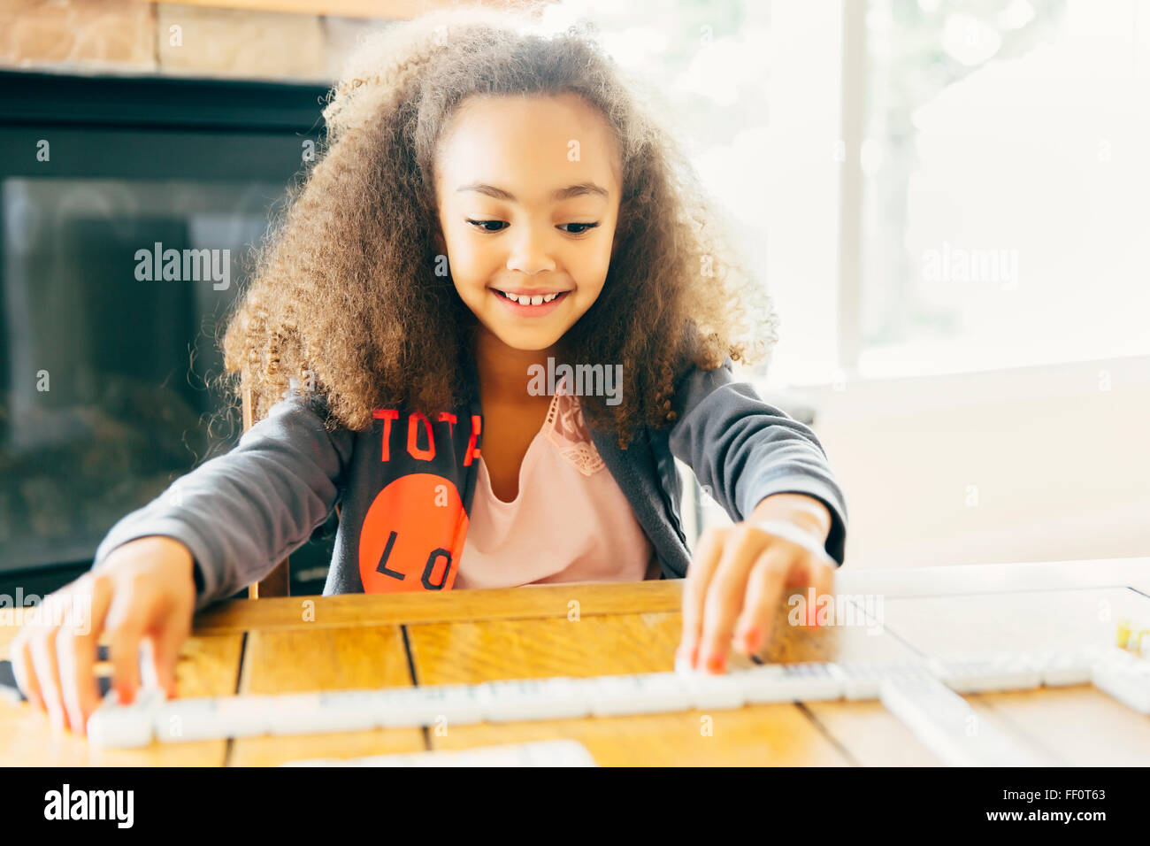 Mixed Race girl Playing with dominoes Banque D'Images