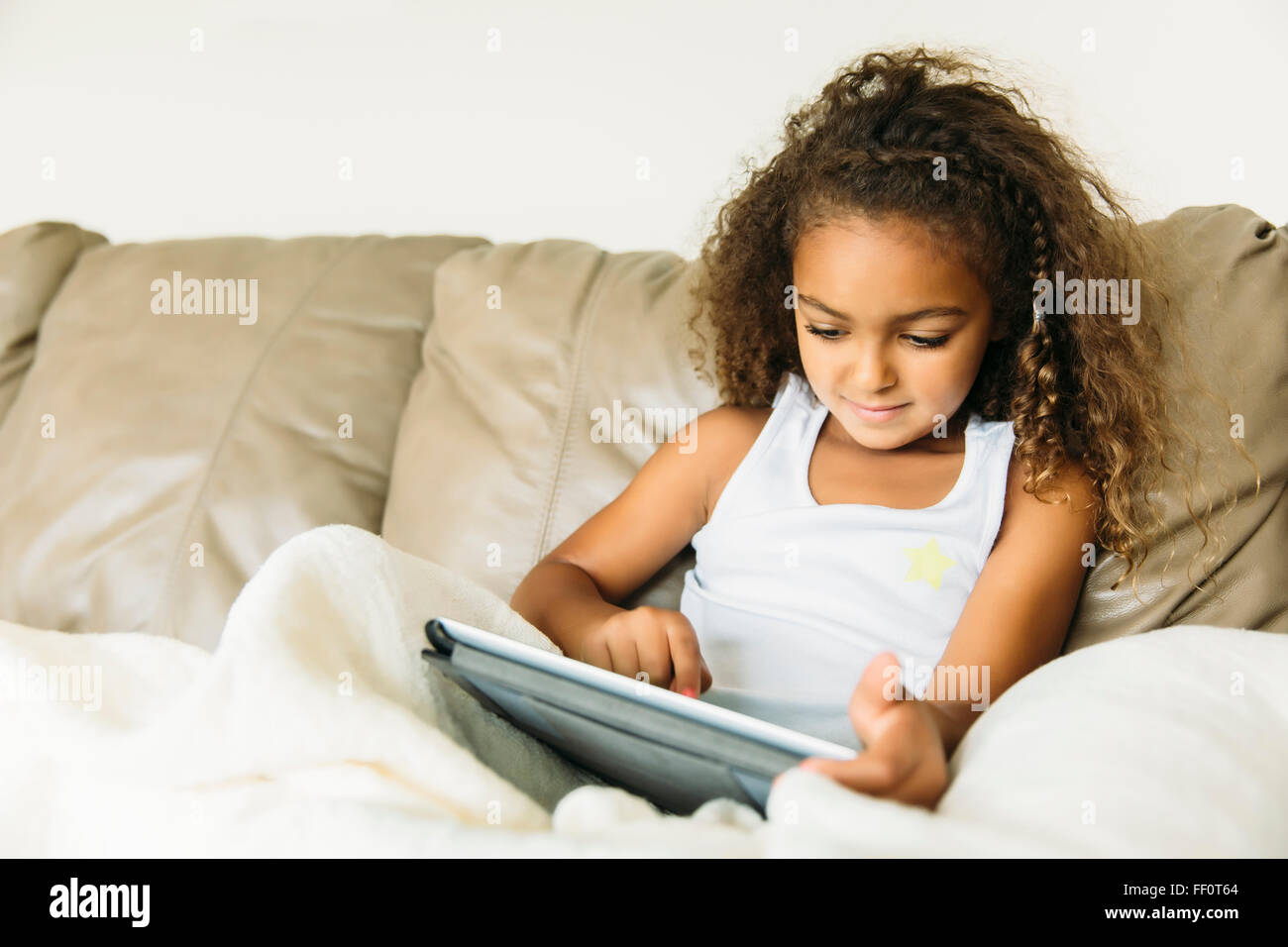 Mixed Race girl sitting on sofa Banque D'Images
