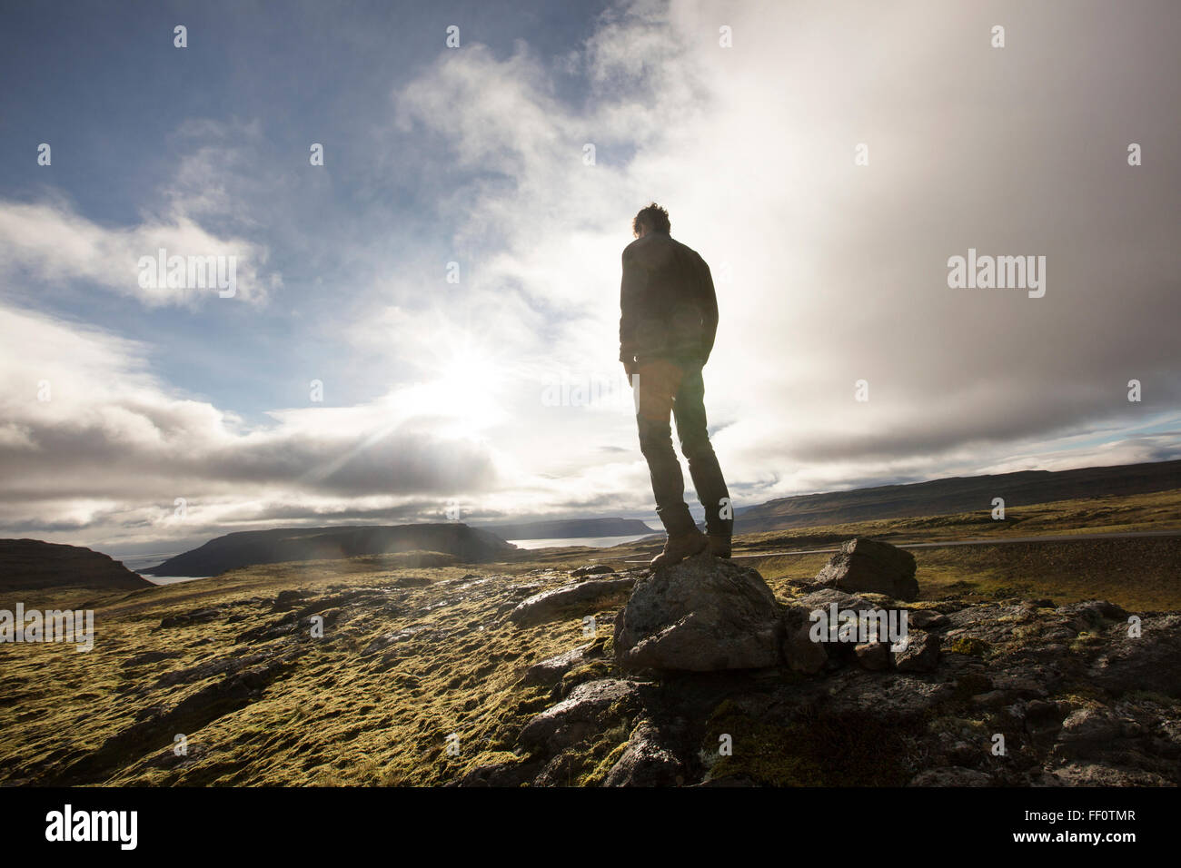 Caucasian man standing on rock in field Banque D'Images