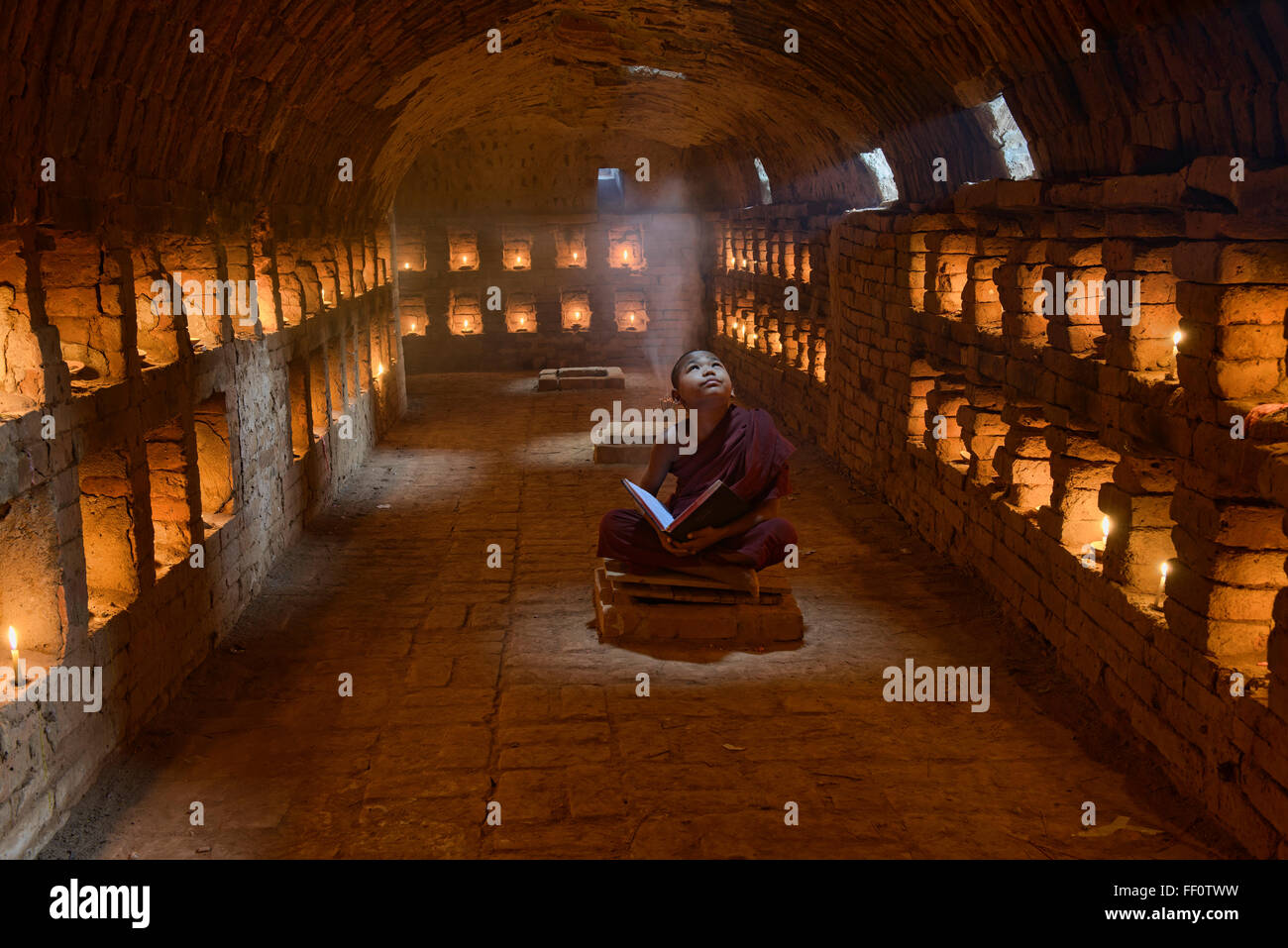 Un jeune moine priant dans les temples de Bagan, Myanmar Banque D'Images